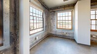 Located at 1131 C St in the heart of downtown Sacramento, this one-bedroom, one-bathroom unit offers a distinctive industrial-chic aesthetic rooted in its historic building origins. Exposed concrete walls bearing the marks of time set a raw, urban tone throughout, while polished concrete floors and exposed ductwork overhead reinforce the loft-style character. Large, multi-pane windows with warm wood frames flood the living areas with natural light and offer views of the surrounding cityscape, enhancing the open and airy atmosphere.

The kitchen is well-appointed with rich dark wood cabinetry, granite countertops, and a full suite of stainless steel appliances, including a range, microwave, and refrigerator — a polished contrast to the rugged industrial backdrop. The spacious primary bedroom features carpeted flooring for comfort, exposed concrete accent walls, and a generously sized window that continues the theme of natural light throughout the unit. Two closets provide ample storage.

The bathroom is cleanly finished with tile-surround tub and shower, a granite-topped vanity, and coordinated fixtures. With its compelling blend of historic industrial character and modern finishes, this unit delivers a one-of-a-kind urban living experience in Sacramento's vibrant downtown district.