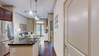 Located at 4310 Dunlavy St in Houston's vibrant Montrose neighborhood, this thoughtfully designed one-bedroom, two-bathroom residence offers an efficient yet refined layout across a single floor. The living room immediately impresses with soaring ceilings, crown molding, and floor-to-ceiling windows that bathe the space in natural light and provide views of the surrounding streetscape. Rich hardwood-style flooring and elegant drapery contribute to the room's polished ambiance.

The gourmet kitchen is a standout feature, showcasing rich cherry wood cabinetry, dark granite countertops, a stone tile backsplash, and a full suite of stainless steel appliances including a professional-grade gas range, built-in microwave, dishwasher, and French door refrigerator. Track lighting and under-cabinet illumination complete the functional and stylish design.

The bedroom is a comfortable retreat, featuring a ceiling fan, a large window with views to the exterior, and plush carpeting. It connects to a dedicated walk-in closet with wire shelving for organized storage. The primary bathroom offers a soaking tub set within marble-look tile surround, complemented by a vanity with rich wood cabinetry and granite countertops. A second full bathroom serves guests with equal refinement and easy hall access.