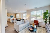 Located at 2320 Clubhouse Station Pl in Waldorf, MD, this two-story home offers 2 bedrooms, 3 bathrooms, and a well-designed layout spread evenly across two floors. The main level features an open-concept living, dining, and kitchen area filled with natural light from multiple large windows. The living room provides a welcoming, airy atmosphere, while the kitchen stands out with light wood cabinetry, stainless steel appliances including a range and over-the-range microwave, white quartz countertops, a subway tile backsplash, and a breakfast bar with seating. The dining area offers additional windows and direct access to the outdoors. Hardwood-style flooring runs throughout the main living areas, adding warmth and continuity. The upper level hosts the two bedrooms, including a primary suite with a walk-in closet and natural light from dual windows. Three full bathrooms are distributed across both floors, each finished with wood-tone vanities and white countertops. Additional conveniences include a dedicated laundry area, ample closet storage, and an attached garage with automatic opener. The neutral color palette and clean, modern design create a bright, cohesive aesthetic throughout the home.