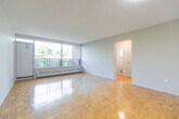 This well-laid-out 2-bedroom, 1-bathroom unit at 1219 Dundas St W in Mississauga offers a comfortable and functional single-floor living space. Warm parquet flooring flows consistently throughout the living areas, hallways, and both bedrooms, lending a classic and cohesive character to the home.

The living room is a standout feature, boasting a large floor-to-ceiling window that frames lush treetop views and fills the room with abundant natural light. The kitchen is thoughtfully updated with grey cabinetry, granite-style countertops, a tile backsplash, and white appliances including a refrigerator and stove, all set on light-toned flooring.

Both bedrooms are bright and well-proportioned, each featuring windows with views of the surrounding greenery and baseboard heating. The primary bedroom offers generous space and connects conveniently to the hallway, which also includes a built-in closet for added storage.

The bathroom is clean and functional, featuring a full tiled tub-shower combination with a window for natural ventilation. Two hallways provide smooth circulation throughout the unit, with a dedicated closet adding practical storage. Overall, the space offers a comfortable, light-filled environment in a convenient Mississauga location.