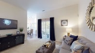 This single-floor, 2-bedroom, 2-bathroom residence at 114 Federal Way in Johnston, Rhode Island, offers a thoughtfully designed layout with comfortable living spaces and modern finishes throughout. The living room features plush carpeting, vaulted ceilings, and sliding glass doors with floor-to-ceiling drapes that open to a private outdoor area, allowing an abundance of natural light to fill the space. Adjacent to the living room, the dining area is bright and airy, benefiting from multiple large windows that frame views of surrounding greenery. The kitchen is well-equipped with rich warm-toned cabinetry, granite-style countertops, and a full suite of stainless steel appliances, including a range, over-the-range microwave, dishwasher, and refrigerator, all set atop durable wood-style flooring. Both bedrooms are generously sized with soft carpeting and ample natural light. The two bathrooms feature wood-style flooring, white vanities, and clean, neutral finishes. A dedicated in-unit laundry area with a full-size washer and dryer adds exceptional convenience. The overall ambiance is warm, neutral, and move-in ready, making this residence a practical and comfortable home in Johnston, RI.