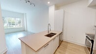 Located at 350 Village Dr in King of Prussia, PA, this one-bedroom, one-bathroom residence offers a well-designed single-floor layout with a clean, modern aesthetic throughout. Light wood-tone flooring runs continuously through the living spaces, complementing the crisp white walls and creating a bright, cohesive atmosphere.

The kitchen is a standout feature, equipped with stainless steel appliances including a full-size refrigerator, range, and microwave. White flat-front cabinetry extends to the ceiling, maximizing storage, while a mosaic tile backsplash adds a subtle decorative touch. A quartz countertop with an integrated double-basin sink and a commercial-style spring faucet anchors the space, which also offers recessed lighting overhead.

The combined kitchen and living area provides an open, functional flow ideal for everyday living. The bedroom features a tray ceiling detail, a large window with horizontal blinds that invites natural light and outdoor views of the surrounding greenery, and ample wall space for furniture arrangement.

The bathroom is finished with marble-look tile flooring, white cabinetry with brushed hardware, a warm-toned quartz vanity countertop, an undermount sink, and a gold-framed mirror with vanity lighting — lending the space a refined, upscale character. A hallway connects the key rooms efficiently, completing this well-appointed residence.