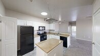 Located at 14681 S 82nd E Ave in Bixby, Oklahoma, this single-floor, three-bedroom, two-bathroom home offers a practical and comfortable layout across a well-utilized footprint. The kitchen serves as a central highlight, featuring crisp white shaker cabinetry, granite-style countertops, a subway tile backsplash, and a full suite of black appliances including a refrigerator, electric range, microwave, and dishwasher. A center island provides additional prep space and storage, while a decorative hanging pot rack overhead adds a functional design touch. Wood-look vinyl flooring runs through the kitchen and entry areas, transitioning to plush carpet in the living and bedroom spaces. The primary bedroom is generously sized and features a tray ceiling with crown molding detail, a ceiling fan, a private door to an outdoor balcony or patio, and a walk-in closet with built-in wire shelving. Additional bedrooms are carpeted and well-lit with natural light from windows fitted with blinds. The bathrooms include granite-topped vanities and a tub/shower combination with clean white surround. A dedicated laundry room with side-by-side washer and dryer hookups and built-in shelving adds everyday convenience. Three closets throughout the home provide ample storage.
