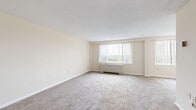 Located at 8484 16th St in Silver Spring, MD, this one-bedroom, one-bathroom residence offers a practical and comfortable layout across a single floor. The expansive living area is a standout feature, dressed in neutral carpet and bathed in natural light through large windows fitted with vertical blinds. A baseboard heating unit runs beneath the windows, and the open feel of the room is enhanced by its generous proportions and clean, cream-toned walls.

The kitchen is efficiently designed with warm wood cabinetry, light granite-style countertops, and hardwood flooring. It is equipped with a gas range, a full-size refrigerator, and a dishwasher, providing a fully functional cooking space.

The bedroom is a comfortable retreat featuring plush carpeting, neutral walls, and a ceiling fan with a built-in light fixture. An adjacent closet offers a full-width hanging rod, providing ample storage.

The bathroom is finished in classic white, featuring white subway tile wainscoting, mosaic tile flooring, a combined tub and shower, a vanity with a mirror, and clean, timeless fixtures throughout.

This residence offers a bright, neutral palette and a well-organized floor plan, making it a practical living space in a convenient Silver Spring location.