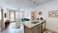 This two-bedroom, two-bathroom unit at 12300 Moores Lake Rd in Chester, VA offers a well-designed single-floor layout that maximizes functionality. The open-concept kitchen is a standout feature, boasting granite countertops, a peninsula with bar seating, stainless steel appliances including a refrigerator, range, and microwave, and gray cabinetry with ample storage. Pendant and track lighting add a modern touch, while wood-style flooring flows throughout the main living areas. The in-unit laundry room includes a full-size washer and dryer, adding everyday convenience. The primary bedroom is generously sized, featuring plush carpeting, a ceiling fan, and a warm accent wall. It is complemented by a spacious walk-in closet with wire shelving and hanging rods. The second bedroom mirrors this comfort with its own carpet flooring, ceiling fan, and natural light from a window. Both bathrooms are clean and well-appointed, each offering a tub/shower combination with tile surround, wood-style flooring, and granite vanity countertops. A hallway connects the private areas of the unit, creating a practical flow throughout. The neutral color palette and consistent finishes give the entire space a cohesive, move-in-ready appeal.