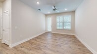 Located at 2500 Peaceful River Dr in Mount Dora, Florida, this one-bedroom, one-bathroom residence offers a thoughtfully designed single-floor layout. Wood-look plank flooring and a neutral color palette flow throughout, creating a clean, cohesive aesthetic.

The open-concept kitchen and living area serves as the heart of the home. The kitchen is outfitted with white shaker cabinetry, granite countertops, a peninsula with seating, recessed lighting, and a full suite of stainless steel appliances, including a range, microwave, and refrigerator. A convenient in-unit laundry room with a full-size washer and dryer is accessible directly from the kitchen.

A hallway connects the living spaces to the private bedroom, which is generously sized and features a ceiling fan, a window with outdoor views, and a dedicated closet. The full bathroom includes a granite-topped vanity and a shower-tub combination with a curved curtain rod.

Additional highlights include a private patio for outdoor enjoyment, recessed lighting throughout, and clean white trim and baseboards that complement the warm flooring. The overall ambiance is bright, modern, and move-in ready, offering comfortable single-level living in the charming Mount Dora community.