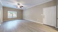 Located at 2650 Western Center Blvd in Fort Worth, TX, this two-bedroom, one-bathroom unit offers a well-organized single-floor layout designed for comfortable everyday living. Light wood-style flooring runs throughout the space, complemented by neutral warm-toned walls and crisp white crown molding and baseboards that lend a clean, cohesive aesthetic.

The living area is bright and open, with a ceiling fan overhead and a window that allows natural light to fill the room. The galley-style kitchen is thoughtfully appointed with white shaker cabinetry, a subway tile backsplash, gray quartz-style countertops, an undermount sink with a gold-toned faucet, and a full suite of black and stainless steel appliances including a range, microwave, and dishwasher.

Both bedrooms continue the wood-style flooring and feature ceiling fans and windows with natural light. The primary bedroom includes access to a dedicated walk-in closet with built-in shelving, while the second bedroom offers a similarly comfortable and functional space.

The bathroom is outfitted with a white vanity with gray countertop, a combined tub and shower with white tile surround, and safety grab bars. The unit also includes a dedicated closet for additional storage needs.