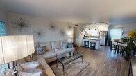 Located at 3001 N 32nd St in Phoenix, AZ, this single-floor home offers a thoughtfully designed open-concept layout with modern finishes throughout. The living area is warm and inviting, featuring wood-look flooring, a large sectional seating area, and an electric fireplace set against a sage-green accent wall. Decorative starburst wall art adds a contemporary touch to the neutral palette.

The kitchen is a standout feature, showcasing crisp white cabinetry, stainless steel appliances including a refrigerator and range, a central island with a quartz-style countertop, pendant lighting, and track lighting overhead — all combining to create a functional and stylish cooking space that opens seamlessly to the living area.

The home includes two bedrooms, each with wood-look flooring and natural light from well-positioned windows with blinds and curtains. One bedroom offers exterior door access, adding versatility to the layout.

Two bathrooms serve the home, each finished with classic white subway tile. One features a bathtub-shower combination, while the other includes a walk-in shower with a decorative pebble-stone floor, offering a spa-like feel. The overall design of the home is clean, modern, and cohesive, making it a comfortable and visually appealing Phoenix residence.