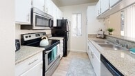 Located at 6152 Stanton Ave in Buena Park, California, this two-bedroom, two-bathroom residence offers a well-designed single-floor layout with a practical and comfortable feel throughout. The combined kitchen and living area serves as the heart of the home. The galley-style kitchen is outfitted with white cabinetry, granite-look countertops, stainless steel appliances including a range, microwave, and dishwasher, alongside a black refrigerator. A window allows natural light to brighten the space, complemented by light wood-style flooring underfoot. The living room extends the open feel with the same flooring, crown molding, and windows that invite in natural light, creating a warm and inviting atmosphere. The spacious primary bedroom features plush carpeting, a large sliding-door closet, and a window with vertical blinds, with direct access to one of the two bathrooms. The second bedroom is similarly carpeted and includes a mirrored sliding closet, adding a sense of depth to the room. Both bathrooms are finished with light wood-style flooring, vanities with granite-look countertops, and shower/tub combinations. Three closets throughout the home provide generous storage. The unit's neutral color palette and consistent finishes create a cohesive and move-in-ready environment.