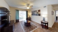 This single-story 2-bedroom, 2-bathroom residence offers a practical and comfortable layout designed for everyday living. The living room serves as the central gathering space, featuring plush carpeting, a ceiling fan, and a sliding glass door that opens to an outdoor patio area, allowing natural light to fill the room. The galley-style kitchen is efficiently designed with light wood cabinetry, gray laminate countertops, a full suite of white appliances including a range and refrigerator, and durable wood-look flooring that adds warmth and easy maintenance.

Both bedrooms are generously sized, each outfitted with soft carpeting, ceiling fans, and large windows that invite in natural light. The primary bedroom includes a walk-in closet and ample space for a full bedroom suite, while the second bedroom also features a reach-in closet for convenient storage. Each room maintains a calm, neutral palette that complements a variety of décor styles.

The two full bathrooms each include a tub-shower combination with tiled surrounds. One bathroom features louvered closet doors and wood-look flooring, while the other is finished with clean white fixtures and decorative framed artwork. Textured ceilings are present throughout the home, adding a classic residential feel to every room.
