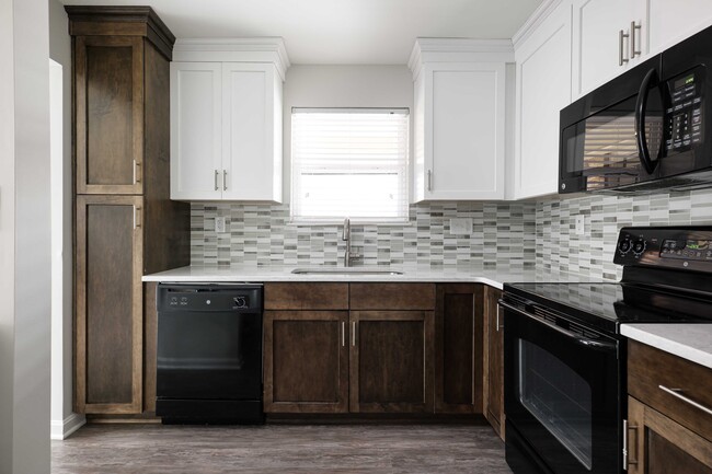 Modern kitchen with custom cabinetry and quartz countertops - The Willows of Plainview