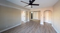 Located in the desirable Clayton Square community in Clayton, MO, this one-bedroom, one-bathroom apartment offers a thoughtfully designed single-floor layout. The living area features warm neutral tones, textured walls, and durable luxury vinyl plank flooring that flows seamlessly throughout the unit. A ceiling fan with a sleek dark finish anchors the space, while elegant arched doorways add a distinctive architectural detail that lends character to the interior.

The living area connects openly to adjacent spaces, creating a cohesive and functional flow. Natural light enters through multiple windows, offering pleasant outdoor views and brightening the neutral color palette. The bedroom is a well-proportioned room equipped with its own ceiling fan, a window with natural light, and the same consistent flooring found throughout the unit.

The bathroom is clean and efficiently appointed, featuring a white vanity with under-cabinet storage, a mirrored medicine cabinet, and a well-lit vanity light fixture above. The tub and toilet complete the practical layout.

Additional highlights include closet space visible from the main living area, built-in ceiling vents for climate control, and clean white baseboards throughout. The overall ambiance is bright, fresh, and move-in ready, making this apartment a practical and comfortable option in the heart of Clayton.