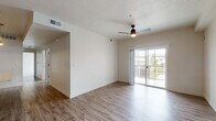 This single-floor residence showcases a thoughtfully designed open-concept layout that seamlessly connects the kitchen, dining, and living areas. The living space is finished with warm-toned wood-look flooring and features a ceiling fan with integrated lighting. Sliding glass doors lead to a private balcony, allowing natural light to fill the interior while providing outdoor views.

The kitchen is a standout feature, equipped with rich dark wood cabinetry extending to the ceiling, stainless steel appliances including a refrigerator, electric range, and built-in microwave, complemented by granite countertops and a classic white subway tile backsplash. A kitchen island with a granite surface and integrated sink adds both functionality and style, accented by pendant lighting overhead.

The bedrooms are carpeted for comfort and receive natural light through window blinds. The bathrooms are finished with wood-look flooring, granite-topped vanities featuring dark cabinetry, and a tub-shower combination with white tile surround and a curved curtain rod. Throughout the unit, neutral wall tones and consistent finishes create a cohesive, modern aesthetic.
