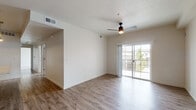 This single-floor residence showcases a thoughtfully designed open-concept layout that seamlessly connects the kitchen, dining, and living areas. The living space is finished with warm-toned wood-look flooring and features a ceiling fan with integrated lighting. Sliding glass doors lead to a private balcony, allowing natural light to fill the interior while providing outdoor views.

The kitchen is a standout feature, equipped with rich dark wood cabinetry extending to the ceiling, stainless steel appliances including a refrigerator, electric range, and built-in microwave, complemented by granite countertops and a classic white subway tile backsplash. A kitchen island with a granite surface and integrated sink adds both functionality and style, accented by pendant lighting overhead.

The bedrooms are carpeted for comfort and receive natural light through window blinds. The bathrooms are finished with wood-look flooring, granite-topped vanities featuring dark cabinetry, and a tub-shower combination with white tile surround and a curved curtain rod. Throughout the unit, neutral wall tones and consistent finishes create a cohesive, modern aesthetic.