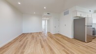 Located at 10934 Peach Grove St in the North Hollywood neighborhood of Los Angeles, this thoughtfully designed 2-bedroom, 2-bathroom residence offers a clean, modern aesthetic across a single floor. Light wood-style flooring flows seamlessly throughout, complementing the bright white walls and recessed lighting that give the space an airy, open feel.

The open-concept living and dining area is generously proportioned, with recessed lighting and direct access to a private balcony through sliding glass doors, bringing in abundant natural light and outdoor views. The kitchen is well-appointed with white shaker cabinetry, quartz countertops, stainless steel appliances including a range and dishwasher, and a deep undermount sink — offering both style and functionality.

Both bedrooms are comfortably sized, each featuring mirrored sliding closet doors that enhance the sense of space and light. The primary bedroom includes its own closet and connects to a well-designed bathroom. A dedicated laundry area and additional closets throughout provide ample storage.

The two bathrooms are finished in a crisp, contemporary style with white vanity cabinetry, quartz countertops, and full tub-and-shower combinations enclosed by sleek sliding glass doors. A connecting hallway ties all rooms together efficiently, completing this well-organized and move-in-ready residence.