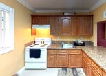 Located at 10820 SW 200th Dr in Cutler Bay, Florida, this single-story home offers a well-organized and functional layout throughout. A tiled entryway hallway with crown molding leads into the main living areas, setting a clean and cohesive tone for the interior.

The living room is a comfortable gathering space featuring large-format glazed tile flooring, crown molding, a textured ceiling, and a front-facing window that brings in natural light with views of tropical landscaping. The room is anchored by a wall-mounted large-screen TV with ambient LED backlighting, adding a modern touch.

Adjacent to the living room, the dining area features a bold accent wall in deep red, crown molding, and an open pass-through to the kitchen, creating a connected and social atmosphere. The kitchen is equipped with rich wood cabinetry, granite countertops, and a full suite of appliances, offering ample storage and workspace.

The bedrooms continue the home's warm color palette of peach and earth tones, with crown molding, tile flooring, and windows providing natural light. The primary bedroom includes an en-suite bathroom with a granite vanity, wood cabinetry, floor-to-ceiling decorative tile work, and a spacious glass-enclosed walk-in shower with a built-in corner shelf and natural window light.