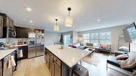 Located at 1625 Marshall Ave in Saint Paul, MN, this single-floor unit offers four bedrooms and two full bathrooms across a well-designed, efficiently laid-out floor plan. The open-concept kitchen and living area serves as the heart of the home, anchored by a large central island with a white quartz countertop and seating for multiple guests. The kitchen is appointed with rich dark wood cabinetry, a classic white subway tile backsplash, and a full suite of stainless steel appliances, including a range, microwave, dishwasher, and French door refrigerator. Pendant lighting above the island adds a modern, polished touch. The living area flows seamlessly from the kitchen, bathed in natural light from large windows and offering access to a balcony. Light wood-toned flooring runs throughout, creating a cohesive, airy feel. Each bedroom is comfortably sized, featuring the same warm flooring, ample closet space with sliding panel doors, and windows that bring in natural light. The two bathrooms are consistently finished with dark wood vanities, white quartz countertops, large mirrors, and wood-look tile flooring. The overall aesthetic is clean, modern, and functional — an ideal layout for shared or family living in the heart of Saint Paul.