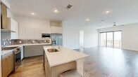 This well-appointed 2-bedroom, 3-bathroom residence offers a thoughtfully designed single-floor layout that maximizes both comfort and functionality. The open-concept kitchen and living area serves as the heart of the home, featuring wood-look flooring, recessed lighting, and a large center island with a quartz countertop and built-in sink. The kitchen is outfitted with stainless steel appliances, including a French door refrigerator, built-in microwave, and a gas range beneath a sleek stainless steel range hood, all complemented by two-tone cabinetry and a textured tile backsplash. A dedicated pantry provides additional storage. The living area extends seamlessly to a private patio through floor-to-ceiling sliding glass doors, inviting an abundance of natural light. Both bedrooms are carpeted and generously sized, with the primary suite offering a particularly spacious footprint. The primary bathroom features marble-style tile flooring, a glass-enclosed walk-in shower, and a modern floating vanity with ample cabinet storage. Five closets throughout the home — including walk-in options with multi-tiered shelving and hanging rods — ensure excellent organization. A dedicated laundry room houses a full-size washer and dryer. The overall aesthetic is clean and contemporary, with neutral tones creating a bright, welcoming ambiance throughout.