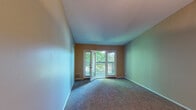 Located at 510 W Chelsea Cir in Fort Mitchell, Kentucky, this single-floor residence offers a functional and comfortable layout across several well-defined living spaces. The living area is generously proportioned, featuring wall-to-wall carpet and vaulted ceilings that lend a sense of openness. A set of glass doors leads directly to a private balcony overlooking mature trees, allowing natural light to fill the room and providing a pleasant outdoor view. A ceiling-mounted light fixture adds practical illumination to the space.

The dining area sits adjacent to the living space, distinguished by its own pendant light fixture and vaulted ceiling detail, with an open passage connecting to the kitchen. The kitchen is well-appointed with light wood cabinetry, granite-style countertops, a black electric range with overhead ventilation, and a decorative mosaic tile backsplash that adds visual interest.

The bedroom includes plush carpeting, neutral-toned walls, and a sliding-door closet with built-in shelving, offering organized storage. The bathroom features a full-sized soaking tub and shower combination with white tile surround. Throughout the residence, a cohesive warm color palette and consistent carpeting create a comfortable, unified ambiance.