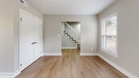 Located at 200 Mal Mae Ct in Williamsburg, VA, this two-story, 3-bedroom, 2-bathroom home offers a clean, modern aesthetic throughout. The main floor features an open-concept living and dining area with warm wood-look flooring, neutral gray walls, and abundant natural light from multiple windows. The fully updated kitchen is a standout, boasting white shaker cabinets, quartz countertops, a classic subway tile backsplash, stainless steel appliances including a refrigerator, dishwasher, and range, and durable wood-look flooring. A hallway with ample closet storage connects the main living areas, with a carpeted staircase leading to the upper floor. Upstairs, three bedrooms feature plush carpeting, ceiling fans, and natural light from windows with blinds. Each bedroom includes closet space, and the primary bedroom offers a generous layout. Both bathrooms are finished with quartz-topped vanities, framed mirrors, and wood-look tile flooring, with one bathroom featuring a natural light window. A utility room and multiple hallways round out the practical layout of this well-appointed Williamsburg home.