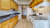 Located at 9532 Muirkirk Rd in Laurel, Maryland, this one-bedroom, one-bathroom residence offers a thoughtfully organized single-floor layout with a generous overall footprint. The entrance leads into a hallway that connects the home's key spaces, including a well-appointed galley-style kitchen featuring warm honey-toned wood cabinetry, dark granite-look countertops, a gas range, white appliances including a dishwasher and refrigerator, and tile flooring — all set beneath a textured ceiling with overhead lighting. Two separate dining areas provide flexible options for everyday meals or entertaining. The carpeted living area is open and bright, benefiting from natural light and access to a private balcony through a sliding glass door dressed with vertical blinds. The spacious bedroom also features plush carpeting, a large closet with bifold doors, and a window that invites additional natural light. Two additional closets throughout the home provide ample storage. The full bathroom includes a tiled shower-tub combination with brushed nickel fixtures and tile flooring. A dedicated laundry area and utility room add practical convenience. Textured ceilings are consistent throughout the home, lending a classic residential character to the overall space.