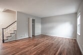 Located at 5371 Wyngate Dr in Norfolk, Virginia, this two-floor home offers a well-organized layout with thoughtfully designed spaces across both levels. The main floor features rich, dark hardwood flooring that flows through the living areas, complemented by neutral gray walls and natural light streaming in through windows. A staircase with a classic wood railing connects the two levels seamlessly. The kitchen is a standout feature, outfitted with crisp white shaker-style cabinetry, granite countertops, stainless steel appliances including a gas range, microwave, refrigerator, and dishwasher, and tile flooring that provides a clean, functional workspace. The upper level transitions to plush wall-to-wall carpeting throughout the bedrooms, each finished with warm beige tones, flush-mount lighting, and sliding or standard closets providing ample storage. Several bedrooms benefit from multiple windows, allowing for generous natural light and views of the surrounding neighborhood. The bathrooms are clean and functional, featuring white tile tub-shower surrounds and neutral finishes. Throughout the home, consistent neutral color palettes, clean white trim, and practical floor plan configurations create a cohesive, move-in-ready environment suitable for a variety of living arrangements.
