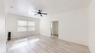 Located at 511 S Serrano Ave in Los Angeles' vibrant Koreatown neighborhood, this efficiently designed single-floor unit offers a thoughtful layout across a living room, kitchen, bathroom, hallway, and two closets. Throughout the space, light wood-style flooring lends warmth and continuity, complemented by crisp white walls that maximize the sense of openness.

The living area is bright and airy, benefiting from multiple windows dressed with slatted blinds that allow natural light to filter in and cast patterns across the floor. A sleek black ceiling fan provides both style and comfort. A cast-iron radiator adds a classic architectural detail.

The galley-style kitchen is a standout feature, showcasing white shaker cabinetry with matte black hardware, striking black marble countertops with white veining, and a modern undermount sink. Stainless steel appliances, including a refrigerator and range, complete the functional and elegant cooking space. Track lighting overhead ensures the kitchen is well-lit.

The bathroom features a full soaking tub with classic white subway-style tile surround and a window that brings in natural light. Two closets provide practical storage solutions throughout the unit. Clean lines, a neutral palette, and modern finishes give this space a polished, move-in-ready feel.