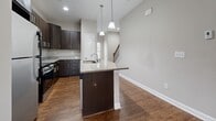 Located at 11945 Crooked Stick Pl in Pineville, NC, this three-bedroom, four-bathroom home is thoughtfully arranged across three floors, offering a versatile and functional layout. The entry level provides a compact yet practical foundation, while the main living floor serves as the heart of the home. Here, a bright and open living room features rich hardwood-style flooring, dual windows, and a ceiling fan, creating a welcoming atmosphere. The kitchen is a standout, showcasing dark espresso cabinetry, granite countertops, stainless steel appliances, and a center island with pendant lighting and an undermount sink — ideal for both cooking and entertaining. A convenient half bathroom with granite vanity and hardwood-style flooring is also found on this level. The upper floor houses the three bedrooms, including a generously sized primary suite with its own en-suite bathroom featuring dual sinks, granite countertops, hardwood-style flooring, and a tiled walk-in shower. The additional bedrooms offer plush carpeting, natural light through slatted blinds, and ceiling fans. Neutral tones and clean white trim throughout lend the home a fresh, move-in-ready aesthetic. Two staircases connect the floors, adding circulation efficiency to this well-designed Pineville residence.