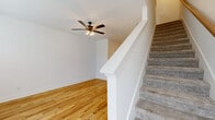 Located at 630 Huntco Drive in Clarksville, Tennessee, this two-story home offers 2 bedrooms and 3 bathrooms across two well-proportioned floors. The main level provides a bright, open living area with light hardwood-style flooring, a ceiling fan with light fixture, and natural light streaming through front-facing windows and a paneled entry door. The kitchen is a standout feature, showcasing gray shaker-style cabinetry, granite countertops, a peninsula with pendant lighting, stainless steel appliances including a range, microwave, dishwasher, and refrigerator, and a matte black sink fixture — all flowing seamlessly into the living space. A half or full bathroom on the main level features hardwood-style flooring, gray vanity cabinetry with matte black hardware, and clean white walls. Carpeted stairs with a white painted banister lead to the upper level, where both bedrooms are found, each with plush neutral carpet and crisp white walls. The spacious primary bedroom includes its own bathroom with a soaking tub, vanity, and classic white fixtures. An additional full bathroom serves the second bedroom. Throughout, the home maintains a clean, modern aesthetic with consistent white trim, matte black accents, and a bright, neutral palette.