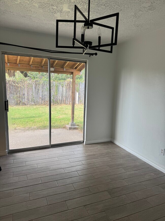 Puertas corredizas de vidrio que dan directamente a un patio, permitiendo la entrada de abundante luz natural. - 10038 Spring Place Dr