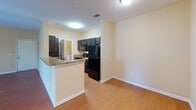 Located at 9449 Dayton Pike in Soddy Daisy, Tennessee, this single-floor unit offers a well-organized layout with a cohesive, warm aesthetic throughout. Rich hardwood-style flooring flows consistently across the main living areas and bedrooms, creating a unified and inviting atmosphere.

The living area is generously sized and bathed in natural light, thanks to a set of French doors that open onto an outdoor balcony. The warm yellow-toned walls complement the flooring and contribute to a bright, welcoming ambiance.

The kitchen is designed for functionality and style, featuring dark cabinetry, black appliances including a refrigerator, microwave, and range, and a granite-topped breakfast bar that connects the kitchen to the adjacent dining or living space. This open-concept arrangement makes the kitchen feel accessible and central to daily living.

The bedroom is a comfortable, well-lit room equipped with a ceiling fan and a window with blinds that allow for natural light and ventilation. The room offers a clean, neutral palette suitable for a variety of furnishing styles.

The bathroom is finished with tile flooring, a full tub and shower combo with a clean white surround, a dark vanity with granite countertop, and chrome fixtures, rounding out the practical amenities of this well-appointed space.