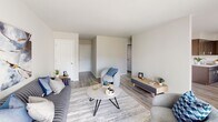 Located at 12 Meadow Rd in Pennsville, NJ, this single-floor residence offers a well-organized layout with a cohesive, modern design. The living room is a comfortable and inviting space featuring light wood-style flooring, neutral walls, and a large sliding glass door that fills the room with natural light and provides views of the surrounding greenery. The open flow connects seamlessly to a dedicated dining area, which includes a window overlooking the exterior and ample room for a full dining set. The kitchen is a standout feature, equipped with rich two-tone cabinetry in warm brown and cool gray tones, marble-look countertops, white subway tile backsplash, and a full suite of stainless steel appliances including a range, refrigerator, and over-range ventilation. Light wood-style flooring carries throughout the main areas, adding continuity. The bedrooms are carpeted for comfort, each offering windows that bring in natural light, wall-unit air conditioning, and closet space with sliding doors. The bathroom features a clean, fully tiled tub and shower enclosure with classic white subway tile and chrome fixtures. Overall, the space presents a fresh, updated feel with a neutral palette that provides a versatile and functional living environment.