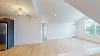 Located at 32976 Redstone Drive in New Baltimore, Michigan, this thoughtfully designed 2-bedroom, 2-bathroom home offers a bright and modern living experience across a single floor. The open living area immediately impresses with soaring vaulted ceilings, recessed lighting, and light-toned hardwood flooring that flows throughout the main spaces, creating a clean and airy atmosphere.

The galley-style kitchen is well-equipped with rich dark cabinetry, white countertops, stainless steel appliances including a range and microwave, and matching hardwood flooring that ties seamlessly into the living area.

Both bedrooms are carpeted in neutral tones and feature ample natural light through large windows with exterior views. The primary bedroom offers generous proportions, while the second bedroom includes a built-in closet with classic panel doors.

The two bathrooms are finished with large-format neutral tile, sliding glass-enclosed shower and tub combinations, and dark-toned vanity cabinetry topped with white counters. The overall design is consistent and polished throughout.

Additional features include a staircase, a utility room, hallway, and dedicated closet space. The home's crisp white walls, modern fixtures, and cohesive finishes make it a clean and functional residence in the New Baltimore community.