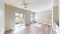 Located at 1275 Central Blvd in Brentwood, California, this single-floor unit offers a clean, modern aesthetic with warm wood-look flooring carried consistently throughout every room. The living area is generously proportioned, bathed in natural light streaming through large windows with blinds and a sliding glass door that opens directly to a private outdoor patio. A ceiling fan adds comfort and airflow to the space, while neutral greige walls create a versatile, move-in-ready atmosphere.

The galley-style kitchen is efficiently laid out with white cabinetry, dark countertops, a stainless steel double sink, a gas range, and a full-size stainless steel refrigerator. A door at the end of the kitchen provides additional access or storage utility.

The bedrooms are well-sized with ample natural light from windows overlooking outdoor greenery. Each room includes a closet — one features a sliding-door closet with built-in rod and shelving — offering practical storage solutions. Neutral tones and consistent flooring maintain a cohesive feel throughout.

The bathroom includes a full-size soaking tub with an overhead shower, complemented by wood-look flooring and clean white finishes, connecting conveniently to the hallway. Overall, the unit presents a bright, functional, and well-maintained living environment.