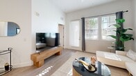 Located at 5942 Factory Shops Boulevard in Ellenton, Florida, this thoughtfully designed one-bedroom, one-bathroom residence offers a cohesive modern aesthetic across its single-floor layout. Light wood-style flooring flows throughout, complemented by crisp white walls that enhance the sense of openness and brightness.

The living room is generously proportioned, featuring tall ceilings, large windows that invite abundant natural light, and direct access to an outdoor area. The kitchen is a standout space, outfitted with sleek dark grey cabinetry, white quartz countertops, a classic subway tile backsplash, and a full suite of stainless steel appliances, including a dishwasher, range, built-in microwave, and a large refrigerator. A kitchen island provides additional prep and dining space.

The bedroom is a comfortable and airy retreat with a ceiling fan, natural light from dual windows, and direct access to the walk-in closet. The closet offers built-in wire shelving for organized storage. The bathroom is elegantly finished with a dual-sink vanity, dark grey cabinetry with chrome hardware, a large wall mirror, and marble-style tile accenting the shower area. The overall ambiance of this residence is clean, contemporary, and move-in ready.