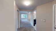 Located at 952 SW Campus Dr in Federal Way, Washington, this single-floor residence offers a well-organized layout with a comfortable, functional design throughout. The living area is a standout space, featuring vaulted ceilings, a tile-surround fireplace, and an expansive wall of windows that frame lush, mature Pacific Northwest trees — filling the room with natural light and a serene outdoor connection. Plush carpeting extends throughout the living areas and bedrooms, adding warmth underfoot.

The kitchen is designed for efficiency, featuring an open peninsula layout that connects seamlessly to the dining area. White cabinetry, dark countertops, a black appliance suite including a range and refrigerator, and a double sink complete the space. A pendant light fixture illuminates the adjacent dining area.

The bedrooms are generously proportioned, each with large windows that invite natural light and views of the surrounding greenery. Baseboard heating provides consistent comfort, and neutral wall tones keep the spaces feeling clean and versatile.

The bathroom is neatly appointed with white cabinetry, dark countertops, a well-lit vanity mirror, and wood-style flooring. A carpeted entry hallway provides a smooth transition between the unit's key areas, rounding out this thoughtfully arranged single-level home.