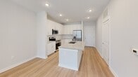 This contemporary 620 square foot apartment in Suwanee, Georgia, offers a thoughtful blend of functionality and style. The open-concept layout maximizes space, featuring a sleek kitchen with white cabinetry, granite countertops, and stainless steel appliances. The kitchen island doubles as a dining area, seamlessly transitioning into the living space.

The single bedroom, measuring 120 square feet, boasts plush carpeting and ample natural light from a large window. Two well-appointed bathrooms feature granite vanities and modern fixtures, with one including a combination shower/tub.

Light wood-look flooring throughout the main living areas creates a warm, cohesive feel. The in-unit laundry room offers full-sized washer and dryer, enhancing convenience. Recessed lighting and modern ceiling fans contribute to the apartment's contemporary ambiance.

Large windows in every room flood the space with natural light, while neutral wall colors provide a blank canvas for personalization. The efficient floor plan makes excellent use of the available square footage, resulting in a compact yet comfortable living space ideal for singles or couples.