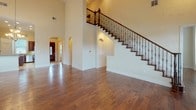 This three-story cottage delivers a well-appointed living experience across four bedrooms and five bathrooms. The grand entryway sets the tone immediately, featuring soaring ceilings, rich hardwood flooring, and a striking staircase with dark wood treads and ornamental wrought-iron balusters. Arched doorways add architectural character as they lead into the main living areas, where natural light filters through multiple windows.

The kitchen is a standout feature, outfitted with rich dark cherry cabinetry, granite countertops, a center island, and a diagonal tile backsplash. A professional-grade stainless steel range with a built-in hood serves as the focal point, complemented by a stainless dishwasher and built-in microwave. Light tile flooring completes the space.

A chandelier-lit dining area connects via a hallway, continuing the hardwood flooring theme. Bedrooms are carpeted and well-sized, offering ceiling fans, crown molding, and ample natural light. Walk-in closets provide generous storage with dual hanging rods and shelving.

Bathrooms are finished with large-format tile flooring, a corner soaking tub, separate glass-enclosed shower, and granite-topped vanities. A dedicated laundry area with tile flooring and built-in shelving adds everyday convenience throughout this thoughtfully designed cottage.