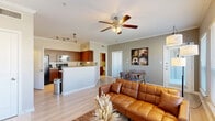 This efficient yet thoughtfully designed 1-bedroom, 1-bathroom single-story residence offers a comfortable and functional living experience across a well-utilized floor plan. The open-concept living and dining area is anchored by light hardwood-style flooring, crown molding, and a ceiling fan, creating an airy and inviting atmosphere. Large windows allow ample natural light to fill the space while offering views of the surrounding area. The kitchen is equipped with rich warm-toned wood cabinetry, stainless steel appliances including a microwave and electric range, and a peninsula with a light countertop that serves as a seamless transition into the living area. Track lighting overhead adds a modern touch. The bedroom is a calm retreat, featuring its own ceiling fan, a dedicated closet, and a window that brings in natural light. It connects directly to the full bathroom, which includes a tub-shower combination and wood-toned cabinetry for storage. The unit also includes an in-unit laundry area, a dedicated closet for additional storage, and access to a private patio. The overall ambiance is clean, modern, and practical, making it an ideal space for comfortable everyday living.