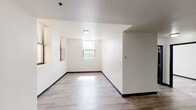 Located at 1905 Elmore St in Cincinnati's 45223 neighborhood, this single-floor unit offers a clean, modern interior with a practical and well-organized layout. Throughout the space, light-toned wood-look flooring and crisp white walls create a bright, cohesive aesthetic, complemented by dark baseboards that add a subtle contrast.

The main living area is generously proportioned, featuring multiple windows fitted with blinds that allow for natural light control while maintaining privacy. An open sightline connects the living area to the entryway, giving the space a sense of flow and connectivity.

The kitchen stands out with its bold blue cabinetry — both upper and lower — paired with warm yellow laminate countertops. A black electric range and a stainless steel double-basin sink complete the functional cooking space, which also includes a vent hood above the range.

The bedrooms are well-sized, each featuring windows that bring in natural light and wood-look flooring consistent with the rest of the unit. The rooms offer clean, neutral walls providing a versatile canvas for personalization.

The bathroom is finished with white tile, a white vanity with under-cabinet storage, a lighted mirror, and a full bathtub with a shower rod. The navy blue door adds a distinctive accent to the otherwise minimalist space. Overall, the unit presents a tidy, move-in ready environment.