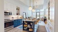 Located at 2195 Celebration Blvd in the master-planned community of Celebration, Florida, this single-floor residence delivers a refined blend of modern design and coastal-inspired charm. The open-concept layout connects the kitchen, dining, and living areas seamlessly, creating an inviting flow throughout the home. Soaring ceilings and oversized windows with transom glass panels flood the interior with abundant natural light and offer pleasant outdoor views.

The kitchen is a standout feature, showcasing striking navy blue lower cabinetry paired with crisp white upper cabinets and open shelving accented with brass hardware. A large center island with a light stone countertop serves as both a prep and casual dining space, complemented by globe pendant lighting with brass fixtures. Stainless steel appliances and a classic subway tile backsplash complete the culinary space.

The living room is generously proportioned with dramatic ceiling height and direct access to an outdoor area through large glass doors. The bedroom offers a tranquil retreat with high ceilings, dual windows, and ample natural light. The bathroom features a dual-sink vanity with navy cabinetry, stone countertops, gold-toned fixtures, and a walk-in glass-enclosed shower with subway tile surround. A stacked in-unit washer and dryer adds everyday convenience.
