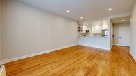 Located at 29 Linden St in Hackensack, NJ, this well-appointed one-bedroom, two-bathroom residence offers a thoughtfully designed single-floor layout with a generous overall footprint. Warm hardwood flooring flows throughout the living areas and bedroom, complemented by neutral-toned walls and clean white baseboards that create a bright, cohesive aesthetic. Recessed lighting and ceiling fans add functionality to the comfortable living spaces, which feature large windows allowing natural light and urban views of the surrounding Hackensack skyline.

The kitchen is a standout feature, boasting white shaker-style cabinetry, light marble-look granite countertops, a classic subway tile backsplash, open wood floating shelves, and stainless steel appliances including a range with overhead microwave. Light tile flooring grounds the space with a clean, modern finish.

The spacious primary bedroom includes its own wall unit and a bright window with outdoor views. Two well-organized closets with built-in shelving and hanging systems provide ample storage throughout the unit.

Both bathrooms are sleekly finished in white marble-look tile. One features a soaking tub and shower combination with a dark-toned vanity, while the second offers a glass-enclosed walk-in shower with an elegant rainfall fixture and matching cabinetry — both exuding a polished, contemporary feel.