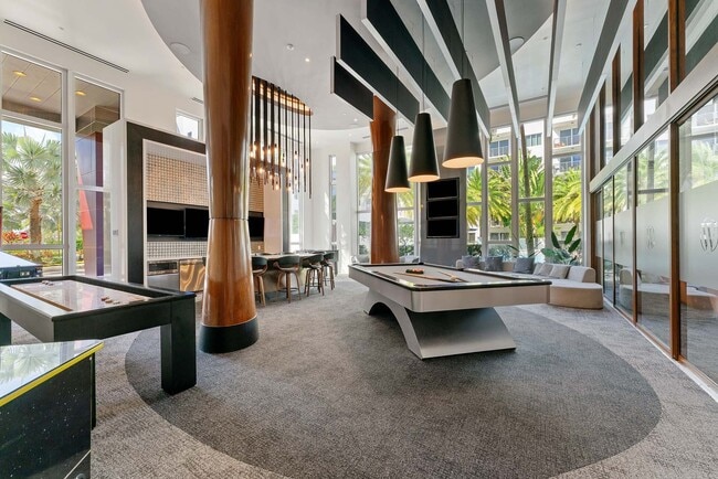 Descanse, juegue y relájese alrededor de una moderna mesa de billar que aporta energía y rivalidad amistosa al corazón del salón. - Windsor at Pembroke Gardens