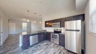 Located at 1206 Robert Rose Drive in Murfreesboro, TN, this two-story home offers a well-designed layout across two thoughtfully proportioned floors. The main level features an open-concept kitchen and living area with durable wood-look flooring throughout. The kitchen is appointed with dark espresso cabinetry, granite-style countertops, a full suite of stainless steel appliances including a dishwasher, range, microwave, and refrigerator, and pendant lighting that adds a modern touch. Natural light flows in through multiple windows, complementing the neutral wall tones. A patio provides outdoor access directly from the main level.

Upstairs, two carpeted bedrooms offer a comfortable retreat, each featuring closets, large windows with blinds, and easy access to the hallway. The primary bedroom includes its own dedicated closet space. Three bathrooms serve the home, including a clean, white tub-shower combination. Additional functional spaces include a laundry area, utility room, and ample storage via two closets. Textured ceilings and clean white trim are consistent throughout, giving the home a tidy, uniform aesthetic. A carpeted staircase connects the two floors, completing this practical and move-in-ready residence.