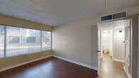 Located at 4554 Hercules Ave in El Paso, Texas, this single-story, 2-bedroom, 1-bathroom home offers a practical and straightforward layout. The interior is organized around a central hallway connecting all living areas, including a living room, kitchen, two bedrooms, and a shared bathroom, along with two dedicated closets for storage.

The kitchen features white cabinetry, white appliances including a gas range and refrigerator, a double sink, and rich dark hardwood flooring. A peninsula counter adds a functional workspace and subtle separation from adjacent areas. Natural light filters in through a window above the sink.

Both bedrooms are carpeted and bathed in natural light from large windows fitted with horizontal blinds. The primary bedroom includes direct access to the bathroom and offers a comfortable, well-proportioned layout. The second bedroom is similarly sized with neutral walls and a cozy ambiance.

The shared bathroom is finished with classic white subway tile on the walls and around the tub/shower combo, complemented by hardwood flooring and a ceiling-mounted light fixture. The living room is carpeted and features neutral-toned walls, offering a clean, versatile space. Throughout the home, textured ceilings, painted block-style walls, and consistent warm neutral tones create a cohesive and understated aesthetic.