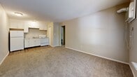 This one-bedroom, one-bathroom unit at 530 Sundown Dr in Independence, Missouri offers a practical and efficient single-floor layout. The open-concept living and kitchen area creates a welcoming central space, with the kitchen featuring white cabinetry, a white range, and a sink along one wall, transitioning seamlessly into the carpeted living area via durable wood-look flooring. The living room is comfortably sized, with a window allowing natural light and views of surrounding greenery, complemented by a wall-mounted AC unit. A hallway connects the main living area to the private bedroom and bathroom. The bedroom is a comfortable retreat, outfitted with plush carpeting, a ceiling fan with light fixture, and a window that frames natural outdoor views. A closet provides convenient storage directly off the bedroom. The bathroom is straightforward and functional, offering a stand-up shower stall, toilet, and wood-look flooring. Neutral, warm-toned walls and textured ceilings are consistent throughout, giving the unit a cohesive and clean aesthetic. A utility room rounds out the layout, adding practical storage or laundry potential. The overall ambiance is calm and understated, well-suited for those seeking a manageable, low-maintenance living space in Independence, MO.