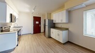 Located at 2752 NE Hogan Dr in Gresham, Oregon, this two-bedroom, one-bathroom unit offers a practical and efficiently organized floor plan across a single level. Light wood-style flooring runs throughout, creating a clean and cohesive look from room to room.

The kitchen and living area share an open layout, anchored by white shaker-style cabinetry, light countertops, and a full suite of stainless steel appliances including a refrigerator, electric range, dishwasher, and microwave. Track lighting overhead provides ample illumination, and a bold wood-toned entry door adds a warm contrast to the neutral color palette.

Both bedrooms are comfortably proportioned, with the primary bedroom offering a dedicated closet. A second closet is also available elsewhere in the unit. One bedroom features a window with outdoor views and a wall-mounted HVAC unit for individual climate control. The second bedroom includes a large sliding closet with rich wood-toned doors that echo the entry door's warm finish.

The bathroom is straightforward and functional, featuring a full tub-shower combination with clean white surround. Throughout the unit, warm beige walls, light flooring, and dark-accented door frames create a simple, modern aesthetic suited for everyday living.