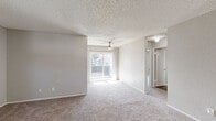 Located at 2060 Westwood Ct in Lancaster, CA, this two-story home offers five bedrooms, two bathrooms, and an attached garage. The main living level hosts the majority of the home's footprint, while the ground floor provides garage access with interior entry. A staircase connects both floors, leading up to open, carpeted living areas brightened by a ceiling fan and a sliding glass door that opens to a balcony, allowing natural light to fill the space. The textured ceilings are consistent throughout, lending a classic residential feel. The kitchen is well-appointed with light-toned shaker-style cabinetry, white countertops, black appliances including a gas range, built-in microwave, and dishwasher, all set over wood-look flooring. The generously sized primary bedroom features plush carpet, a ceiling fan, and a walk-in closet. Additional bedrooms offer ample natural light through large windows with vertical blinds and neutral carpet flooring. Both bathrooms are finished with wood-look flooring, white vanities with under-cabinet storage, and clean fixtures — one featuring a shower-tub combo and the other a stand-up shower. The spacious garage accommodates parking and storage needs with room to spare.