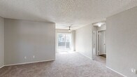 Located at 2060 Westwood Ct in Lancaster, CA, this two-story home offers five bedrooms, two bathrooms, and an attached garage. The main living level hosts the majority of the home's footprint, while the ground floor provides garage access with interior entry. A staircase connects both floors, leading up to open, carpeted living areas brightened by a ceiling fan and a sliding glass door that opens to a balcony, allowing natural light to fill the space. The textured ceilings are consistent throughout, lending a classic residential feel. The kitchen is well-appointed with light-toned shaker-style cabinetry, white countertops, black appliances including a gas range, built-in microwave, and dishwasher, all set over wood-look flooring. The generously sized primary bedroom features plush carpet, a ceiling fan, and a walk-in closet. Additional bedrooms offer ample natural light through large windows with vertical blinds and neutral carpet flooring. Both bathrooms are finished with wood-look flooring, white vanities with under-cabinet storage, and clean fixtures — one featuring a shower-tub combo and the other a stand-up shower. The spacious garage accommodates parking and storage needs with room to spare.