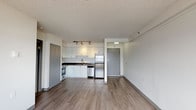 Located on the tenth floor at 29 St. Helens Avenue in Tacoma, Washington, Unit 1002 is a well-appointed residence featuring a thoughtful open-concept layout with clean, modern finishes throughout. The main living area is spacious and bright, with wood-style laminate flooring, neutral-toned walls, and a textured ceiling. Large windows allow natural light to fill the room while offering scenic views of the Tacoma waterway and cityscape beyond, enhanced by a baseboard heating system along the perimeter.

The kitchen is efficiently designed and fully equipped with white cabinetry, dark laminate countertops, a stainless steel refrigerator, dishwasher, and a stainless electric range with a vent hood above. Track lighting illuminates the workspace, and the layout flows seamlessly into the open living area, making the space feel connected and functional.

The bedroom is a well-proportioned room featuring plush carpeting, neutral walls, a textured ceiling, and a window framing views of the water and city. The bathroom is outfitted with a full tub and shower combination, accessibility grab bars, and easy-to-maintain vinyl flooring, reflecting a practical and accessible design. Ample closet space is also present throughout the unit, rounding out this comfortable Tacoma residence.